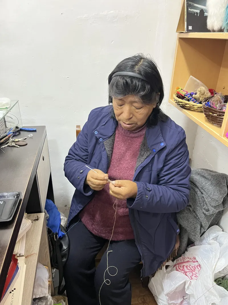 Paula Mamani tejiendo en el taller